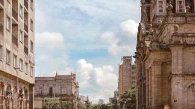 Is Guadalajara Safe? Ultimate Guide for a worry-free trip! 10 people walking near brown ancient cathedral under white and cloudy skies, but is guadalajara safe?