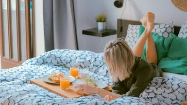 3 Must-Have Travel Essentials for Women on the Go 19 woman lying on bed white holding board of travel essentials for women