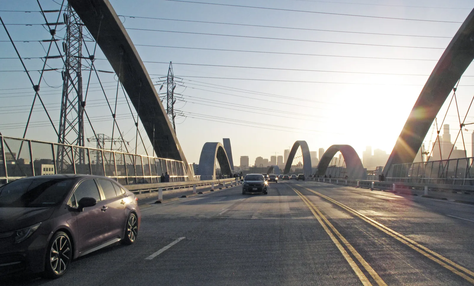 Cars crossing the arched 6th Street Bridge over the LA River toward downtown