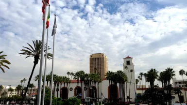 Los Angeles Union Station tower and palm-lined entrance under a cloudy sky